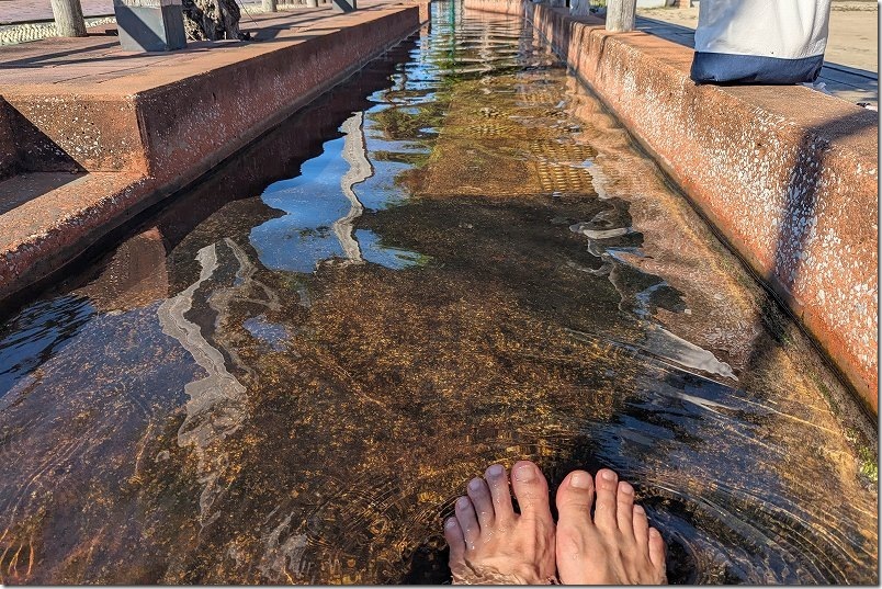 小浜温泉にある日本一長い105メートルの足湯「ほっとふっと105」に足をつける
